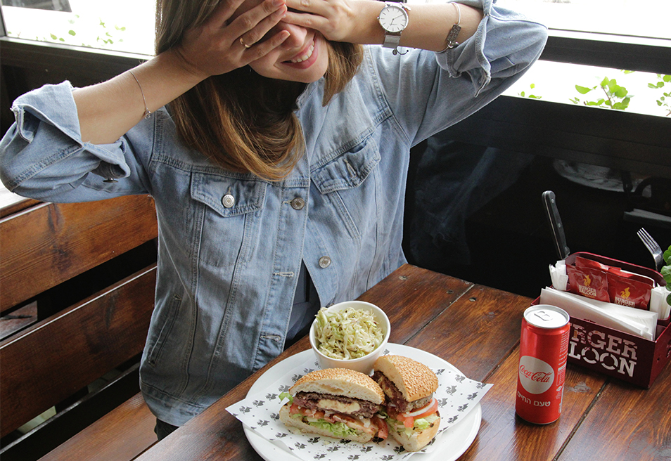 תמונת אווירה של בחורה עם המבורגר וסלט